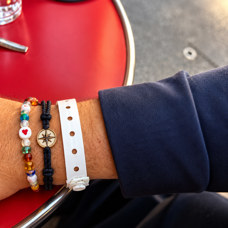 Poignet portant trois bracelets : un bracelet offert pour la fête des Pères, un bracelet symbolisant le chemin de vie et un bracelet d’hospitalisation