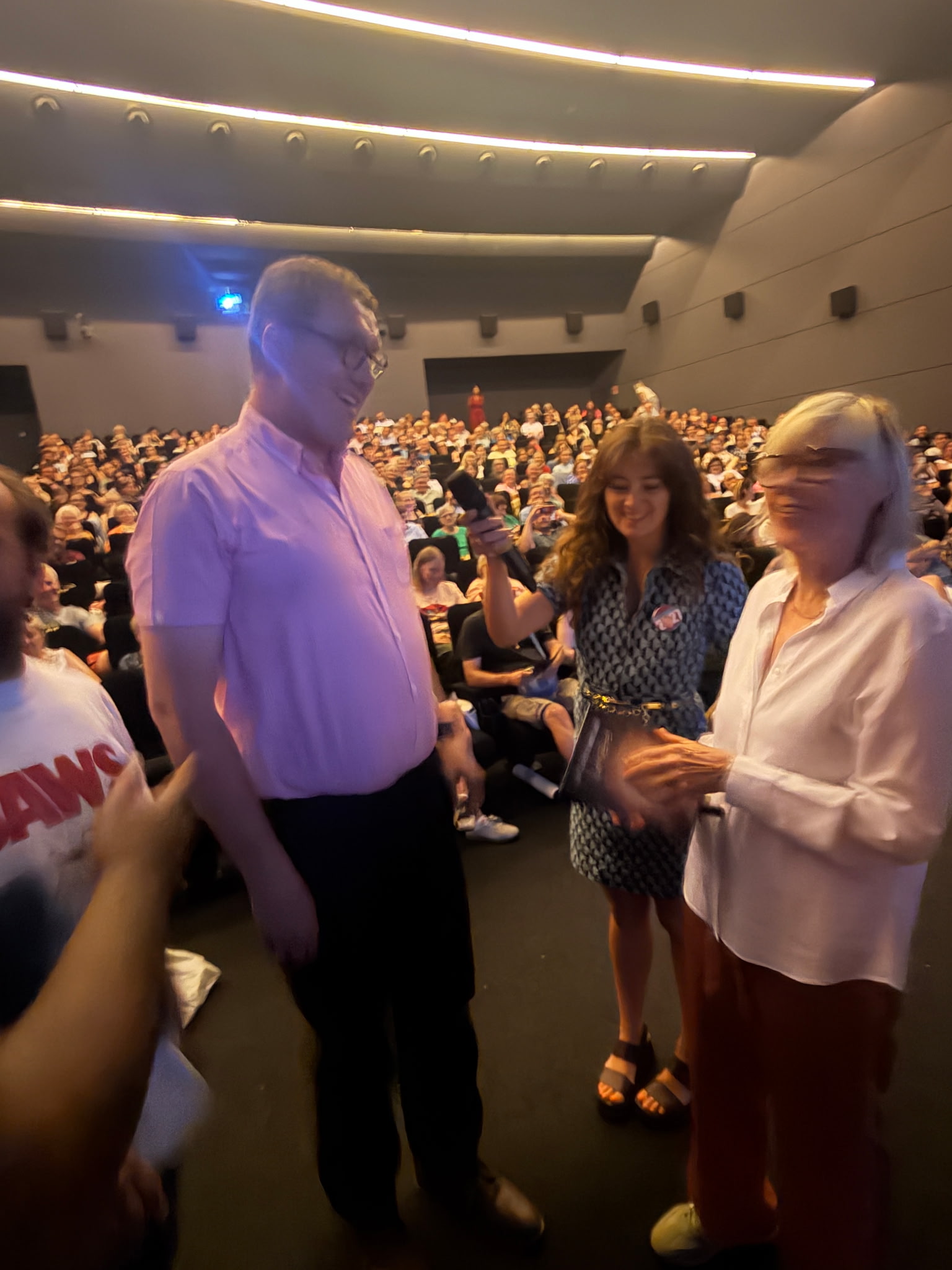 Nicolas Karasiewicz échangeant dans une salle de cinéma pleine lors d’une avant-première.